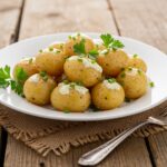 Delicious creamy garlic baby potatoes served beautifully garnished, perfect as a side dish.