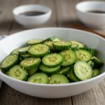A delightful Easy Asian Cucumber Salad ready to enjoy, featuring fresh cucumbers, a savory dressing, and topped with sesame seeds, perfect for any meal.