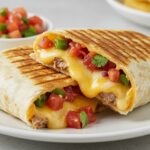 Final presentation of a delicious Grilled Cheese Burrito, highlighting melted cheese and savory salsa, perfect for a satisfying meal.