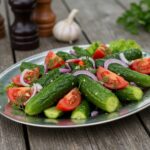 Final presentation of marinated cucumbers, onions, and tomatoes on a platter, showcasing the vibrant colors and fresh ingredients.
