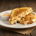 Final presentation of shrimp-stuffed grilled cheese and garlic bread, appetizing seafood dish ready to be enjoyed.