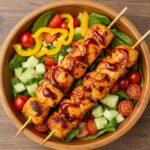 Delicious BBQ Chicken Skewer Salad displayed in a bowl, featuring colorful vegetables, grilled chicken skewers, and a tasty dressing.
