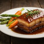 The succulent presentation of Caramelized Honey Glazed Pork Belly, highlighting the dish's rich flavors and appealing texture.