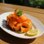 Stunning carrot ribbon salad presented in a white dish, showcasing a healthy and colorful dish perfect for any meal.