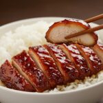 Delicious bowl of Char Siu chicken with tender meat and glossy glaze, ready to be enjoyed, representing a classic Chinese culinary delight.