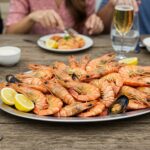 A vibrant and appetizing classic seafood boil served on a platter, featuring shrimp, crab, corn, and lemon wedges ready for a real feast.