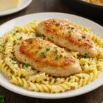 Final presentation of creamy garlic parmesan chicken with cheesy twisted pasta, a delicious and attractive meal.