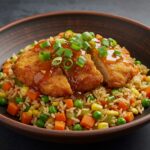 Final presentation of Crispy Saucy Chicken with Vegetable Fried Rice, highlighting vibrant colors and garnishes for an appetizing look.