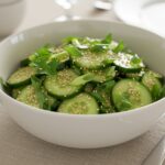 Serving a refreshing cucumber and green onion salad, artfully presented and garnished, perfect for a healthy meal or side dish.