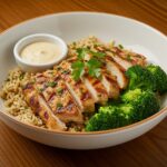 Final presentation of Grilled Chicken & Broccoli Bowls with creamy garlic sauce, ready to be enjoyed.