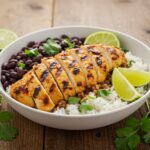 Final presentation of a grilled chicken burrito bowl with vibrant rice and beans, showcasing freshness and flavor.