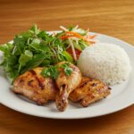 Final presentation of Grilled Vietnamese Chicken with salad and jasmine rice on a rustic table, showcasing a delicious and inviting meal.