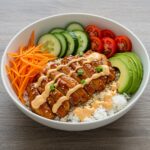 Irresistible spicy honey-ginger chicken bowl with creamy Yum Yum sauce, perfect for an Asian-inspired meal packed with flavor and freshness.