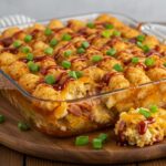 Delicious Loaded BBQ Bacon Tater Tot Casserole presented on a wooden table, garnished and ready to serve, highlighting its scrumptiousness.