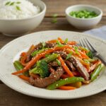 final presentation of minute beef stir fry with vegetables and rice on plate