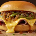 Gourmet presentation of a Philly Cheesesteak Sloppy Joe featuring melted cheese and a hearty filling, perfect for satisfying cravings.