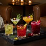 Final presentation of pickle-infused drinks on a serving tray, showcasing vibrant colors and garnishes for an inviting cocktail party.
