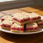 Delicious Raspberry Coconut Bars with Almond Crust on a plate, showcasing the perfect dessert for any occasion.