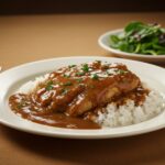 Delicious smothered chicken and rice served on a dining table, a comforting meal that's perfect for family gatherings.