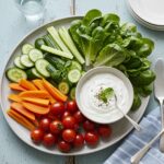 The final result of a Supermodel Snack: a colorful assortment of fresh vegetables paired with a creamy yogurt dip, showcasing healthy eating.
