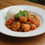 Final presentation of Sweet Chili Chicken served with rice, garnished with cilantro, in a warm and inviting dining setting.