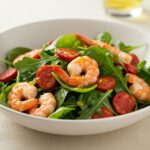 Final presentation of warm shrimp and chorizo salad, showcasing a vibrant mix of chorizo, shrimp, and fresh vegetables for a delicious meal.