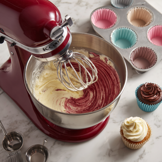 Mixing cupcake batter for red velvet marble cupcakes using a stand mixer, showcasing cream cheese and sugar.