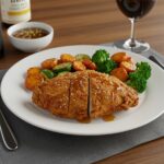 Delicious crispy honey butter chicken served with roasted vegetables, showcasing a perfect meal presentation ready for dining experience.