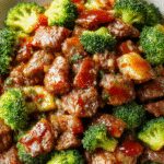 A vibrant stir-fry dish showcasing tender ground beef and bright green broccoli florets glazed in a glossy honey garlic sauce, neatly arranged on a white plate with a sprinkle of sesame seeds and chopped scallions on top, set against a rustic wooden background.
