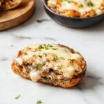 A close-up of a freshly made Swiss Mushroom Melt sandwich showcasing melted Swiss cheese oozing over sautéed mushrooms and toasted bread, garnished with herbs.